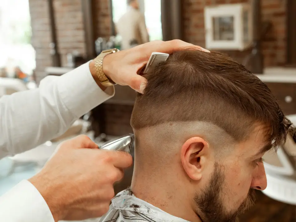 Barbero terminando un corte de pelo