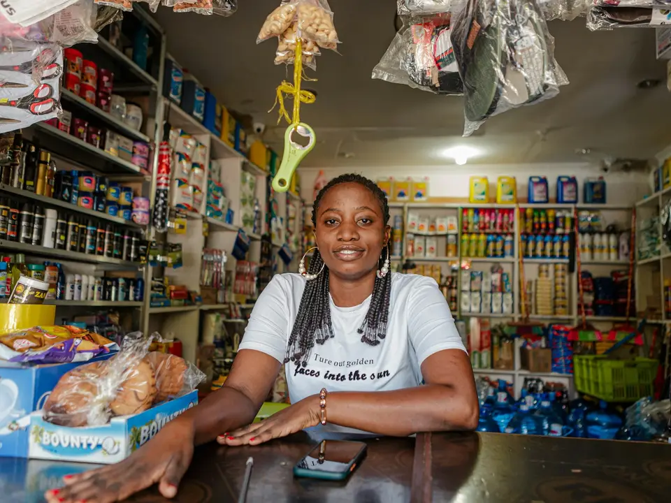 Bodeguera sonriendo detrás del mostrador de su tienda