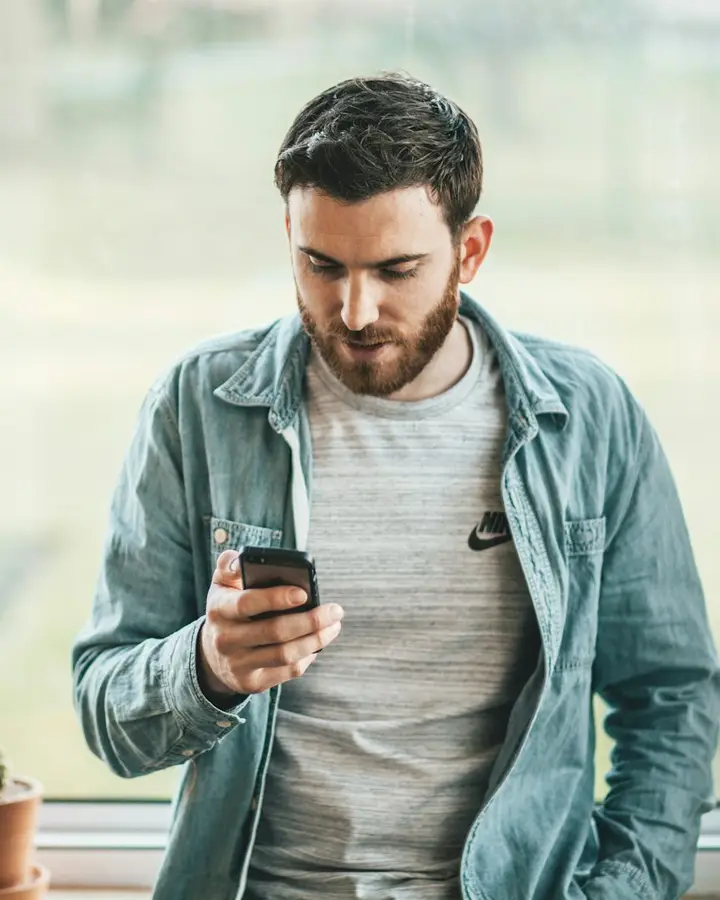 Hombre escribiendo un mensaje en su celular